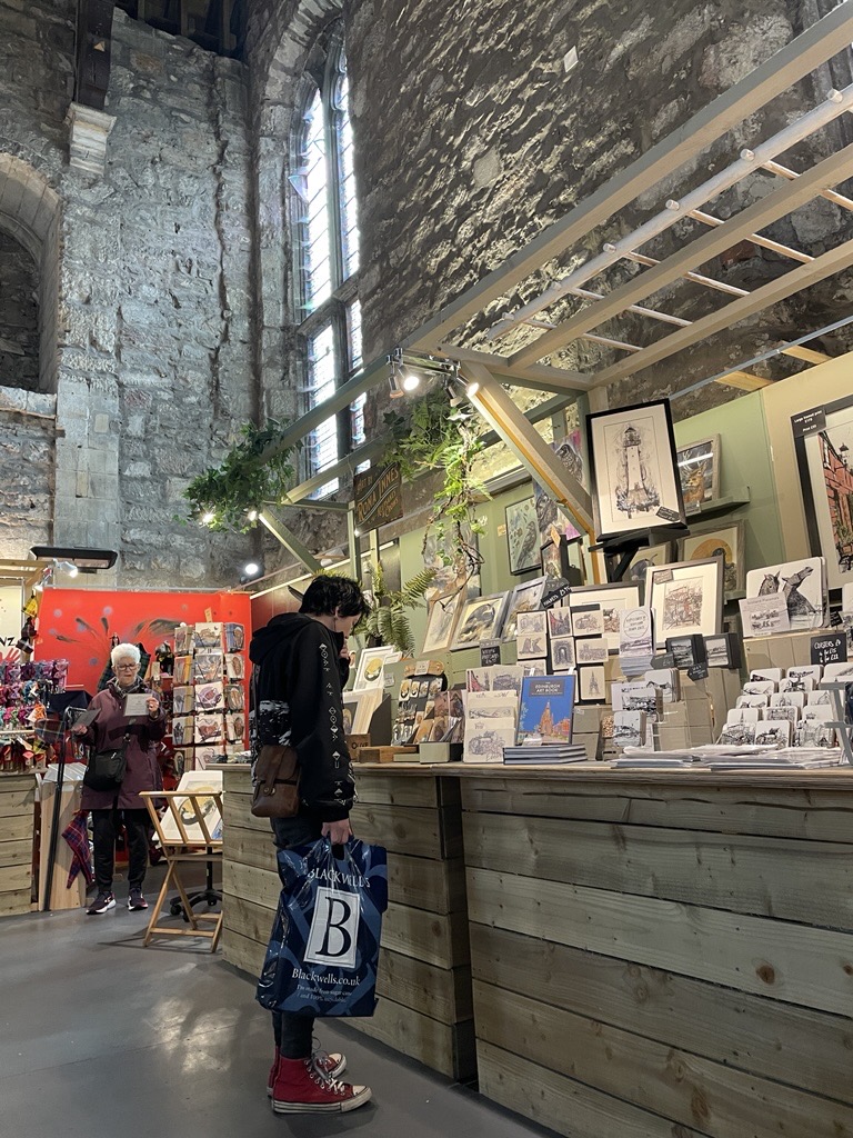 Young woman browsing local crafts at Tron Kirk in Edinburgh