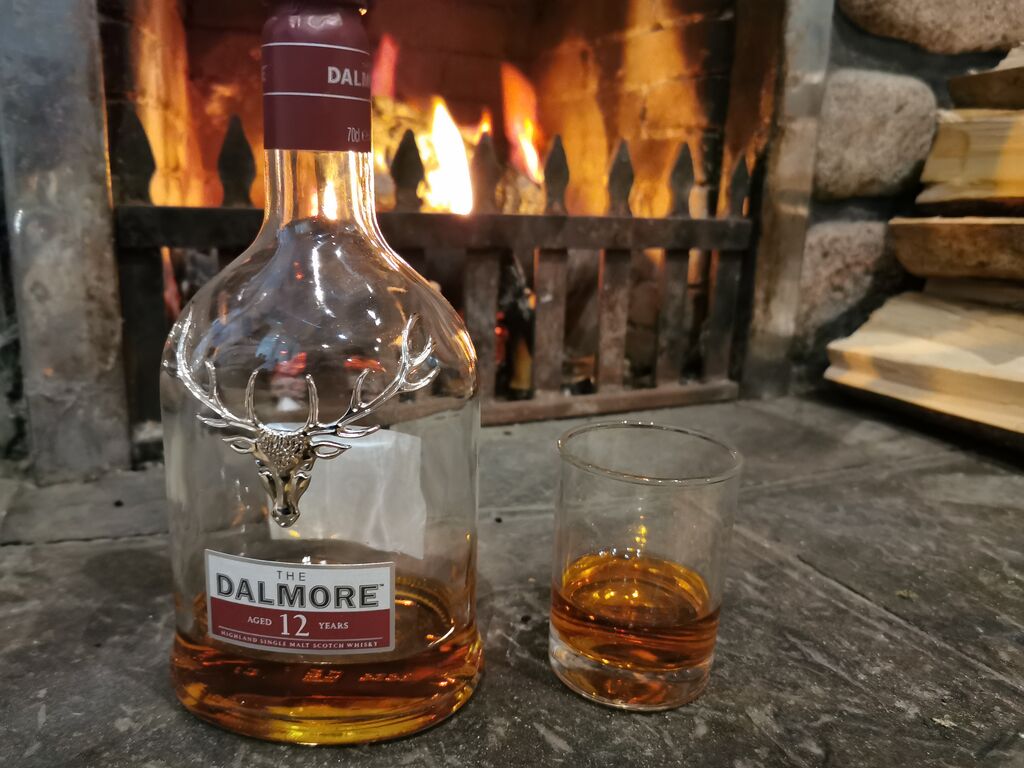 Whisky bottle placed near the fireplace at Morag's Lodge Hostel