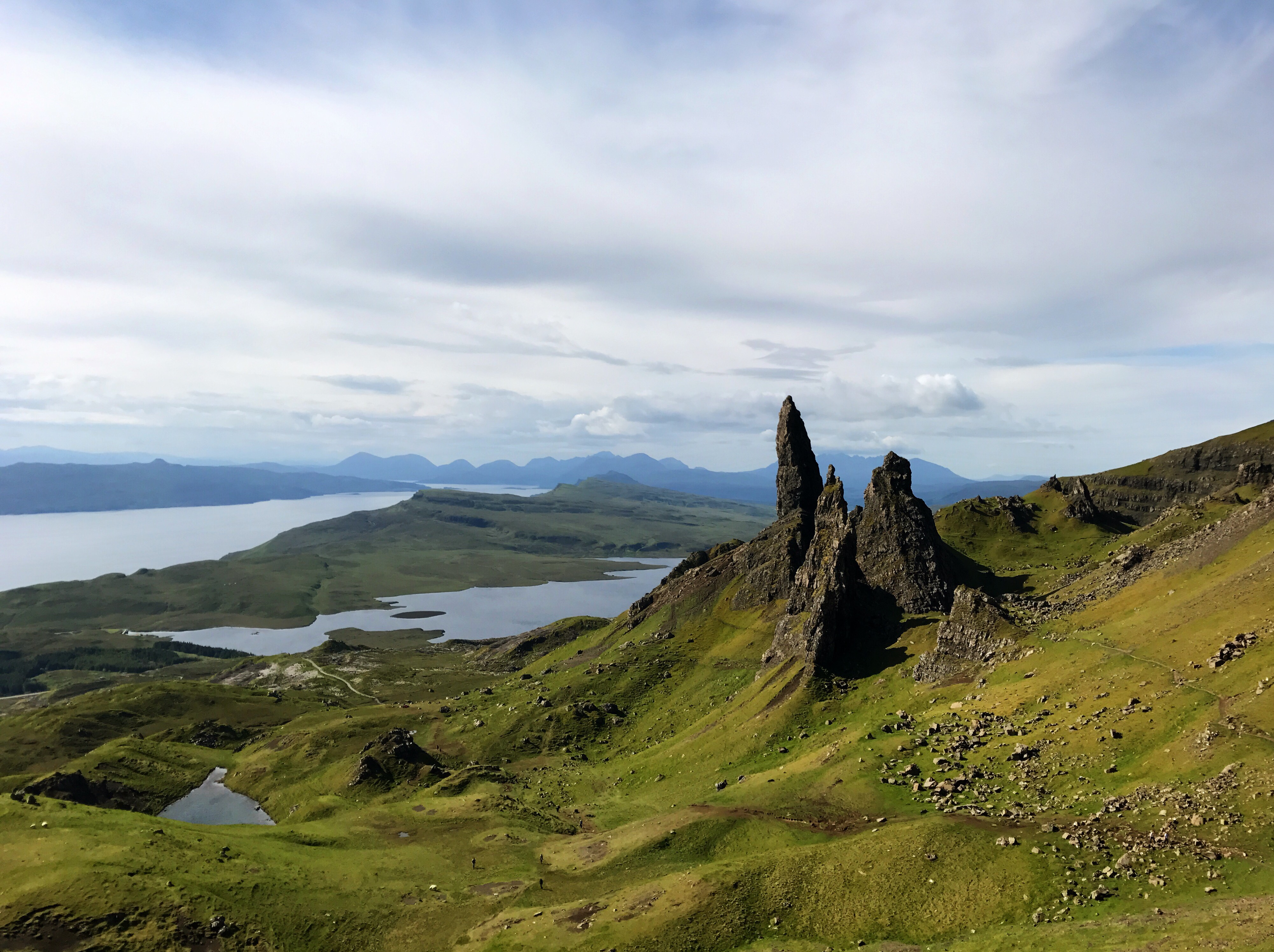 The Old Man of Storr shrouded in mist on a cloudy day, with jagged rock formations rising dramatically